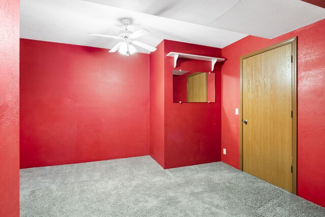 empty room featuring ceiling fan and carpet flooring