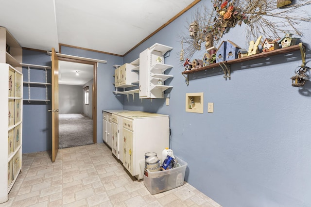 clothes washing area with cabinets, washer hookup, and ornamental molding