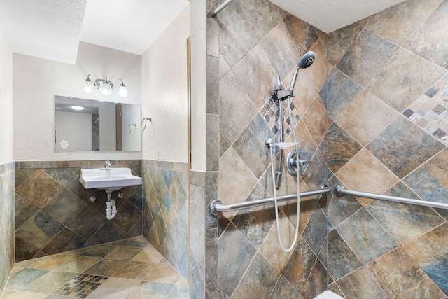 bathroom with tile walls, sink, and a tile shower