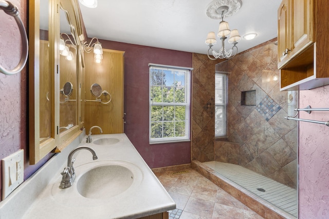 bathroom with tile patterned flooring, vanity, a tile shower, and an inviting chandelier