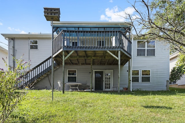 rear view of house with a lawn and a wooden deck