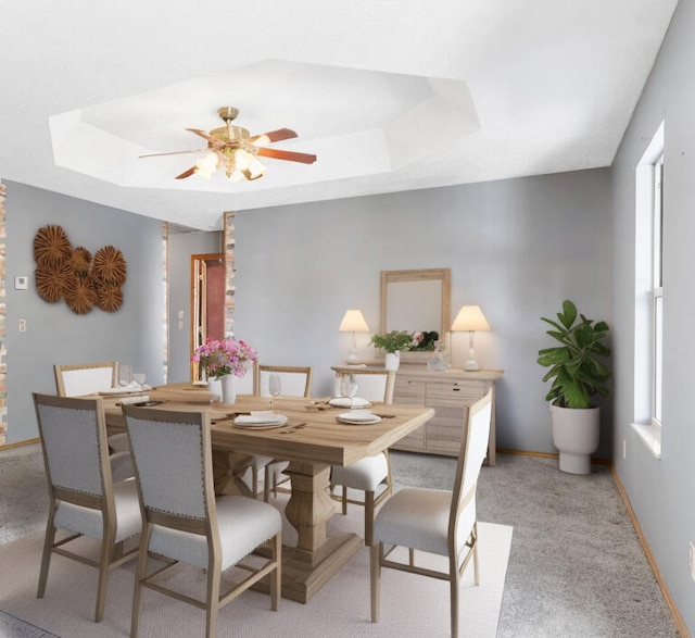 dining room with light colored carpet, ceiling fan, and a tray ceiling