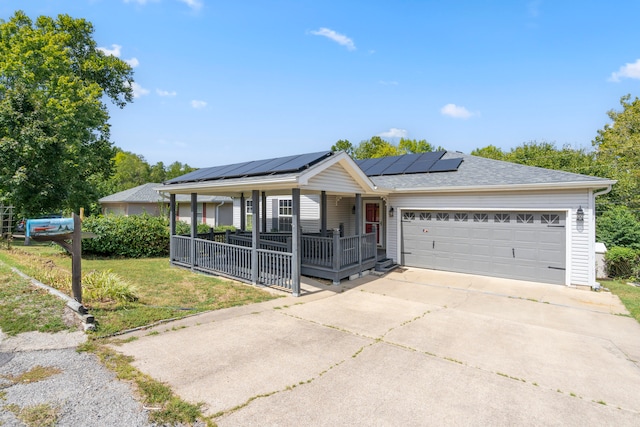 ranch-style house with a front lawn, a garage, and solar panels