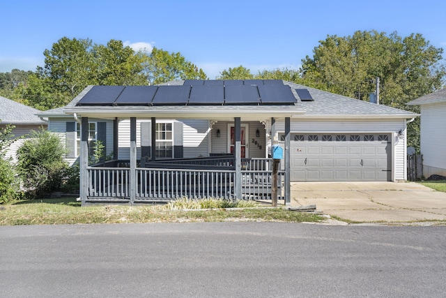 single story home featuring a garage, solar panels, and a porch