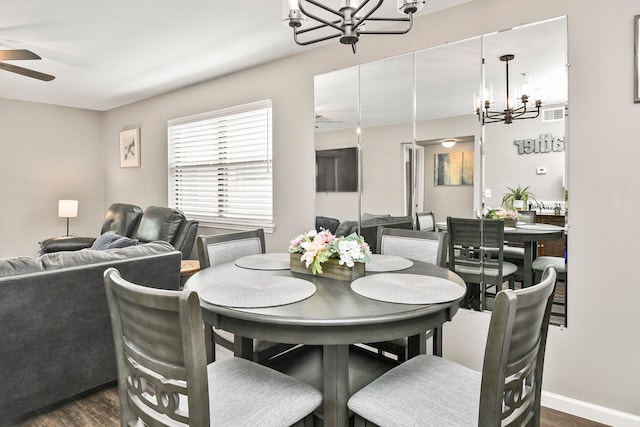 dining room featuring ceiling fan with notable chandelier and dark hardwood / wood-style floors