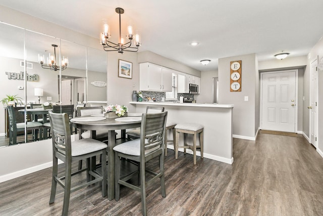 dining area with a notable chandelier and dark hardwood / wood-style flooring