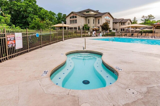 view of swimming pool with a community hot tub and a patio