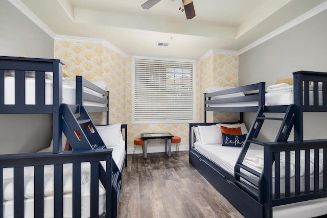 bedroom featuring ceiling fan, a raised ceiling, crown molding, and dark hardwood / wood-style flooring