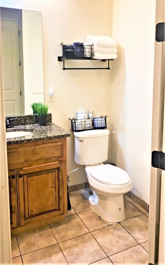 bathroom with tile patterned flooring, vanity, and toilet