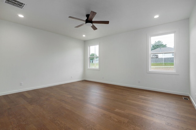 empty room with dark wood-type flooring and a wealth of natural light