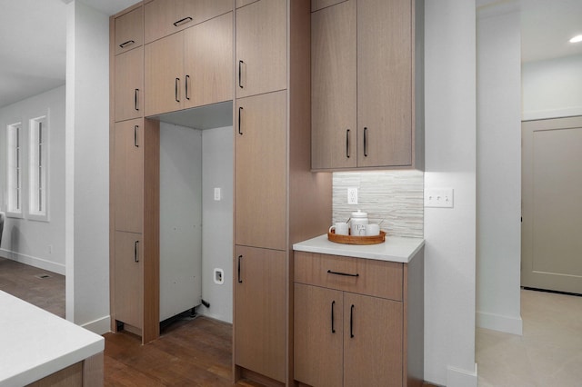 kitchen with decorative backsplash, wood-type flooring, and light brown cabinets