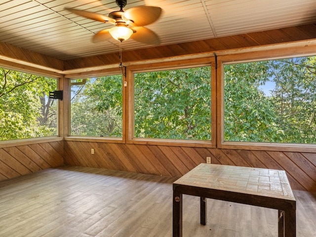 unfurnished sunroom featuring wood ceiling and ceiling fan