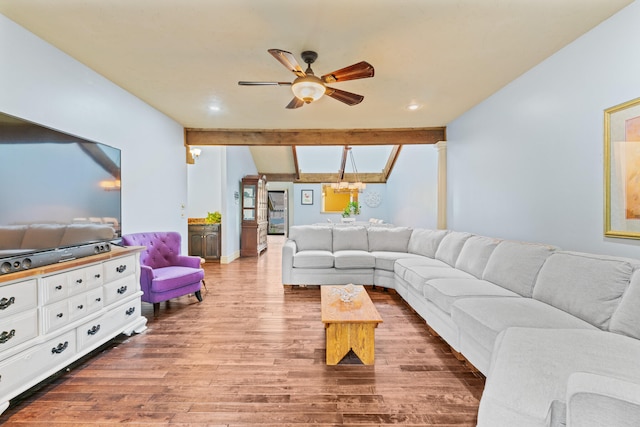 living room with ceiling fan with notable chandelier, beamed ceiling, and wood-type flooring