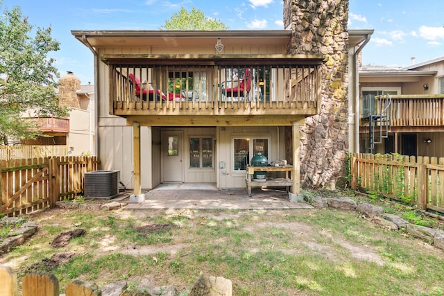 rear view of property with cooling unit and a patio area