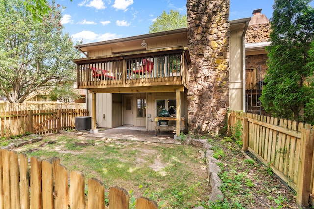 rear view of house featuring central AC unit and a patio area