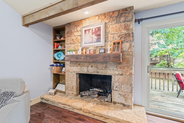 living room with hardwood / wood-style flooring and a stone fireplace