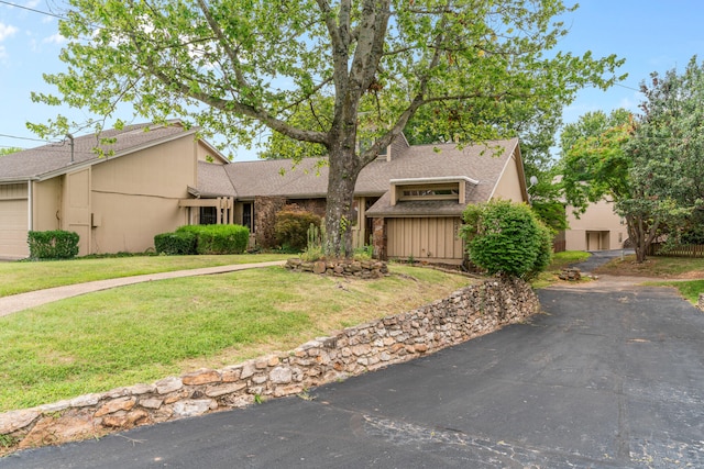 view of front of house featuring a garage and a front lawn