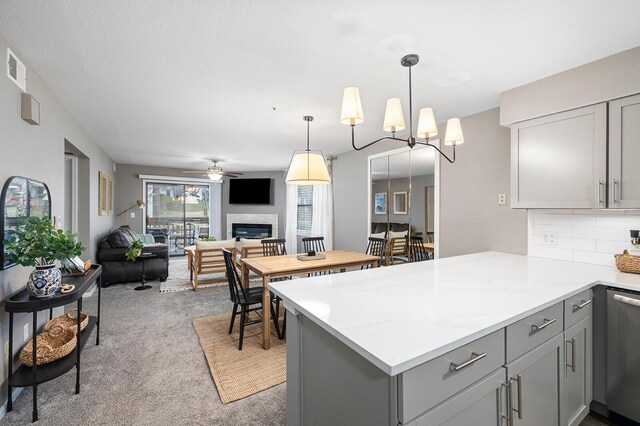 132 Highland Dr Unit 8, Branson, MO 65616 - kitchen with dishwasher, gray cabinets, light carpet, a peninsula, and a glass covered fireplace
