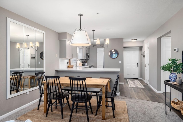 132 Highland Dr Unit 8, Branson, MO 65616 - dining area with dark colored carpet, baseboards, and an inviting chandelier