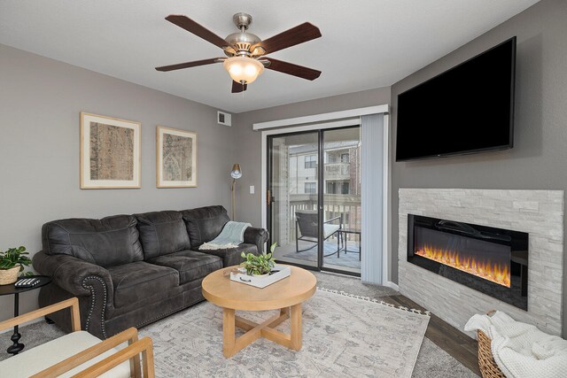 living room featuring ceiling fan, a fireplace, and hardwood / wood-style floors