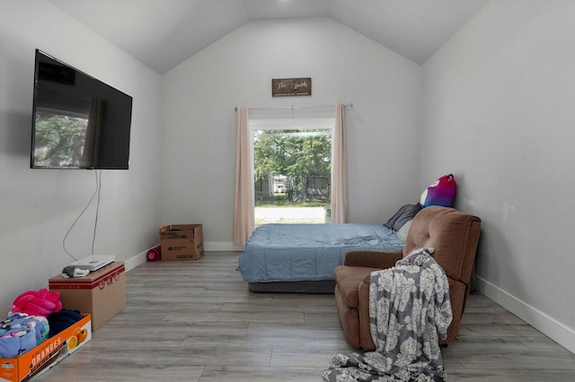 bedroom with light wood-type flooring and vaulted ceiling