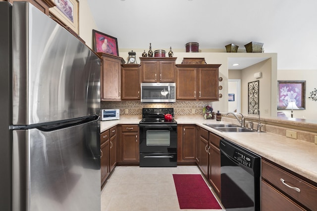 kitchen featuring light tile patterned flooring, sink, decorative backsplash, and black appliances