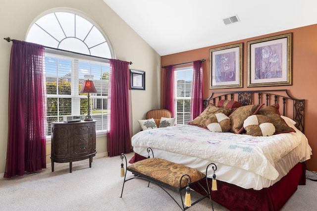 bedroom with light colored carpet and vaulted ceiling