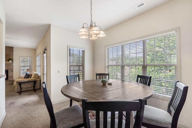 dining space featuring a fireplace, lofted ceiling, a chandelier, and carpet