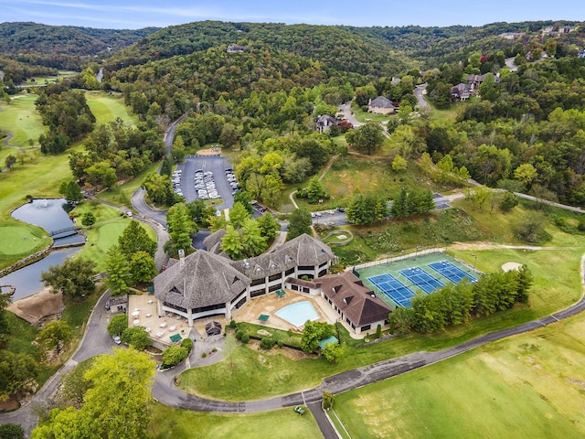 birds eye view of property featuring view of golf course, a water view, and a wooded view