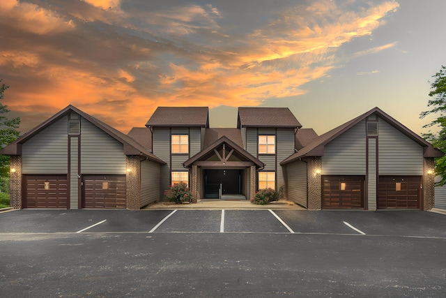 view of front facade with uncovered parking and brick siding