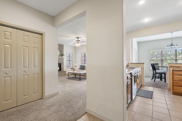 hallway featuring an inviting chandelier and light colored carpet