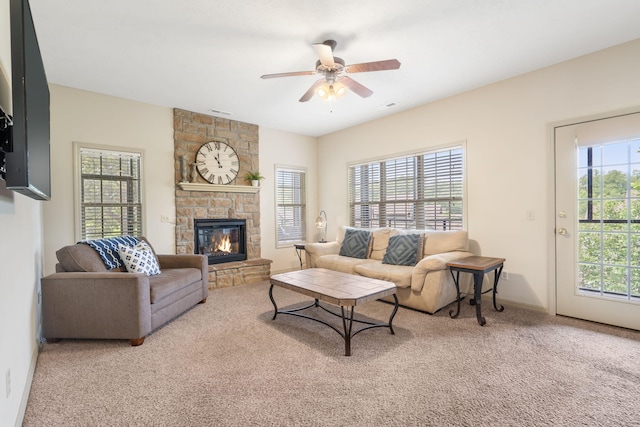 carpeted living room featuring a fireplace and ceiling fan