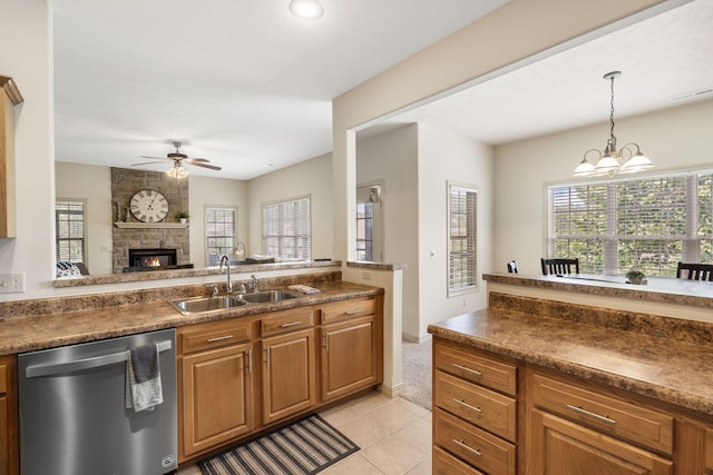 kitchen with stainless steel dishwasher, a sink, ceiling fan with notable chandelier, pendant lighting, and visible vents