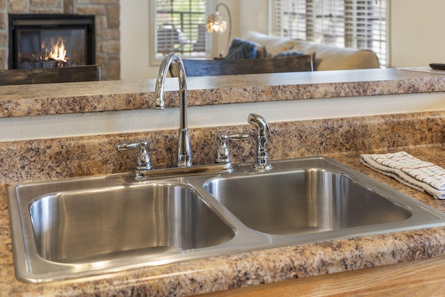 interior details with a lit fireplace and a sink