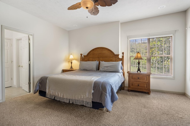 bedroom featuring baseboards, light colored carpet, and ceiling fan