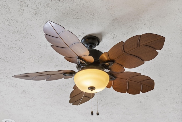 room details with ceiling fan and a textured ceiling