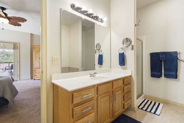 bathroom featuring ceiling fan, vanity, a shower with door, and tile patterned floors