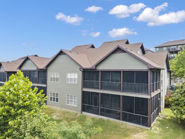 back of house featuring a lawn and a sunroom