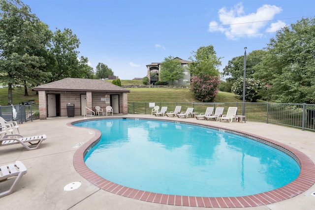 view of pool featuring a yard, a patio, and an outbuilding