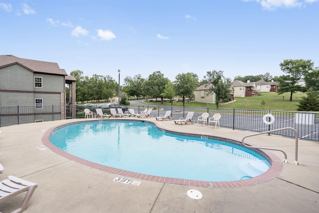 pool featuring fence, a lawn, and a patio