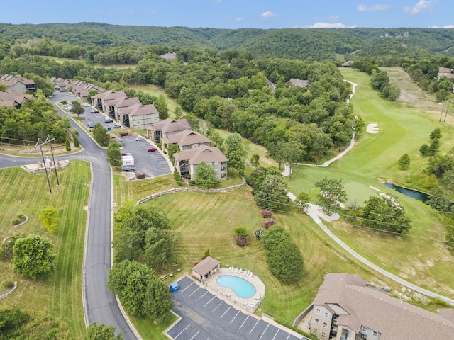 drone / aerial view featuring a view of trees, a residential view, and view of golf course
