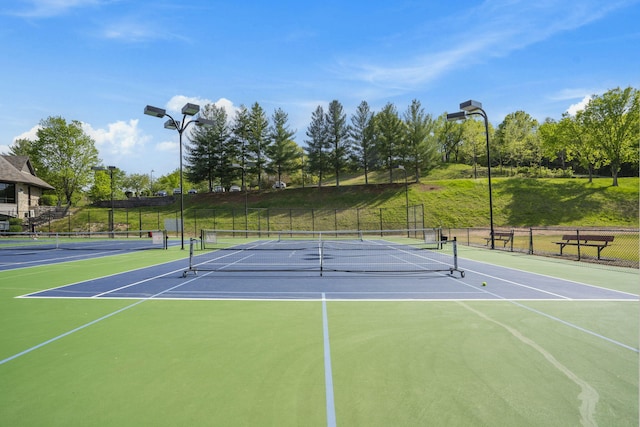 view of tennis court featuring basketball hoop