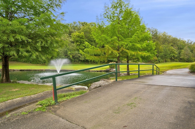 view of home's community featuring a water view and a yard