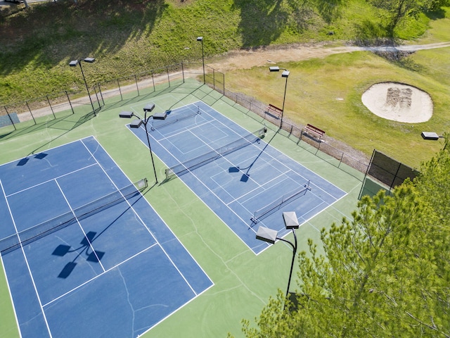 view of tennis court with a yard