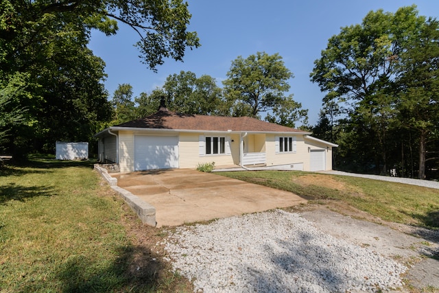 ranch-style home featuring a front lawn, a storage shed, and a garage