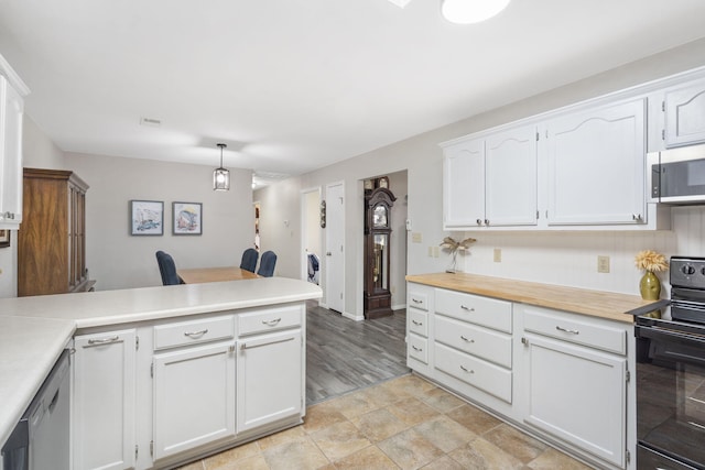 kitchen with kitchen peninsula, appliances with stainless steel finishes, white cabinetry, and hanging light fixtures