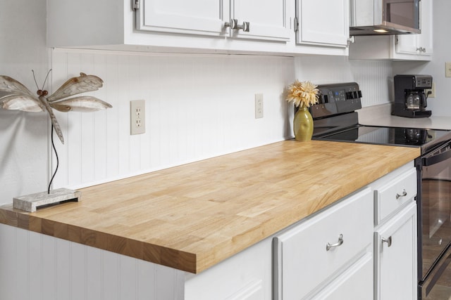 kitchen featuring wood counters, white cabinetry, and black range with electric stovetop