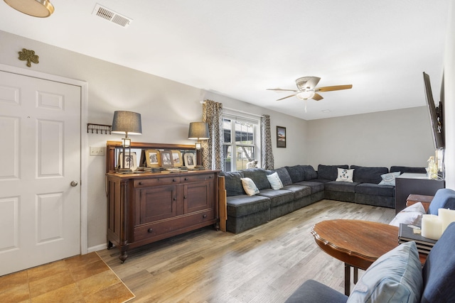 living room featuring light wood-type flooring and ceiling fan