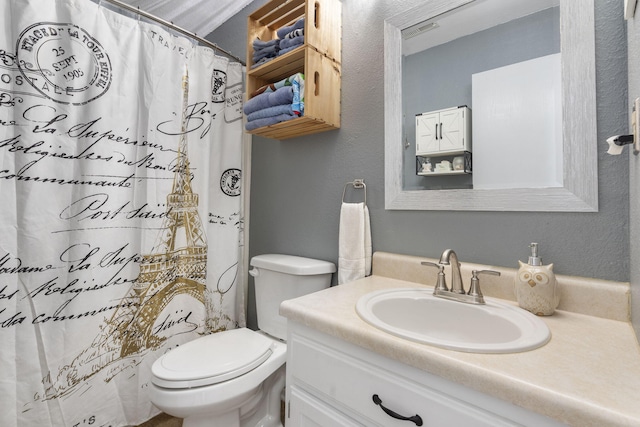 bathroom featuring curtained shower, vanity, and toilet