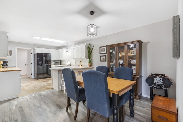 dining space with light wood-type flooring and sink